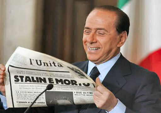 Berlusconi reading an old paper