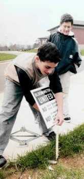 Kids “planting” lawn signs